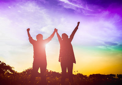 Low angle view of silhouette people standing against sky during sunset
