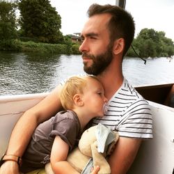 Father and son sitting in boat at lake