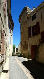 Alley amidst buildings against clear sky