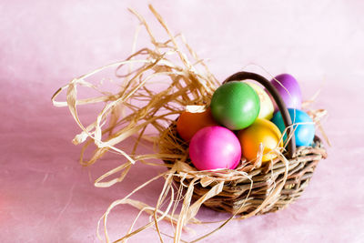 Close-up of colorful easter eggs in wicker basket on table