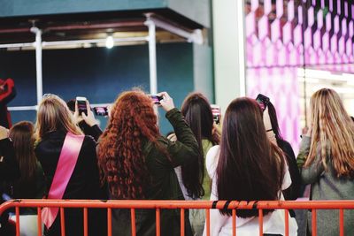 Rear view of women photographing building