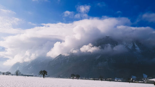 Scenic view of snow covered land against sky