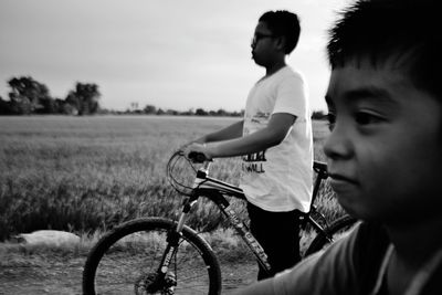 Side view of boy riding bicycle against sky