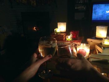 Close-up of hand holding lit candles in the dark
