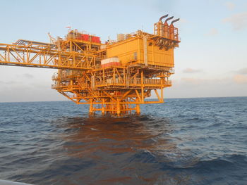 Ferris wheel by sea against sky