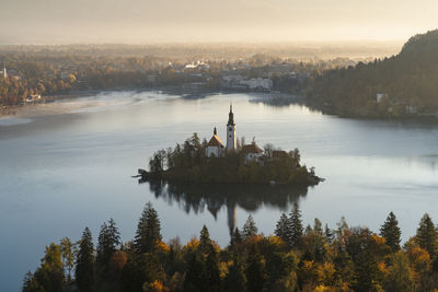 High angle view of trees and church against sky during sunrise in bled, slovenia.