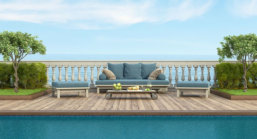 Garden with swimming pool and retro sofa in front of a classic balustrade - 3d rendering