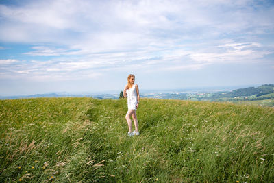 Woman standing on field against sky