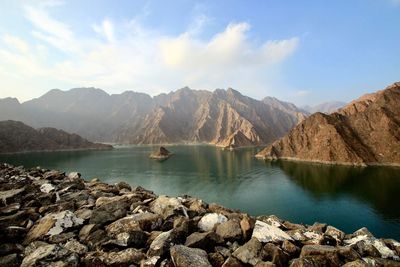 Scenic view of lake by mountains against sky