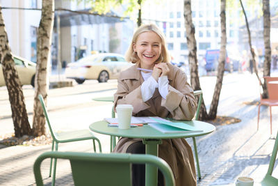 Portrait of young woman sitting on chair