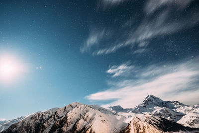 Scenic view of snowcapped mountains against sky at night