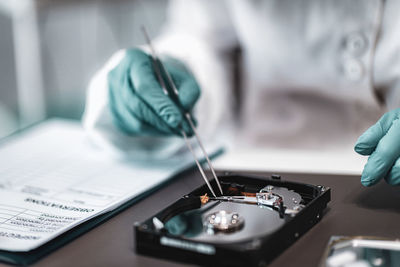 Close-up of man working on hard disk drive