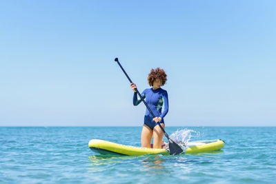 Man jumping in sea against clear sky