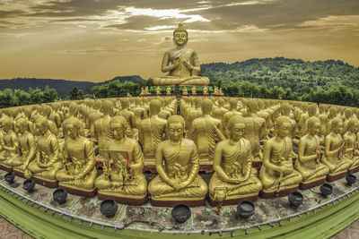 Statue of buddha and building against sky