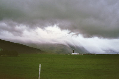 Scenic view of field against cloudy sky