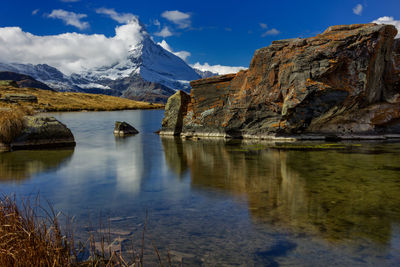 Scenic view of lake by mountains against sky