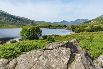 Scenic view of lake by mountains against sky