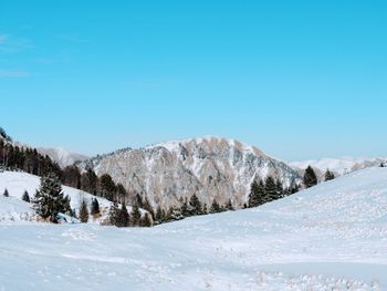 Scenic view of snowcapped mountains against clear blue sky