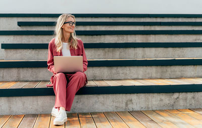 Portrait of young woman sitting on staircase