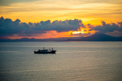 Boat on sea against orange sky