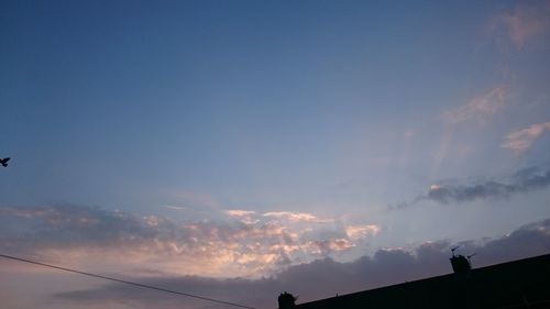Low angle view of silhouette cables against sky at sunset