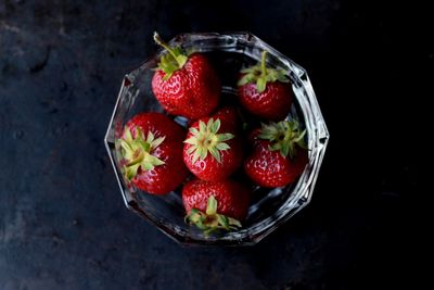 Close-up of strawberries in bowl against black background