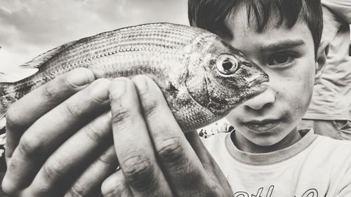 Close-up portrait of boy holding camera