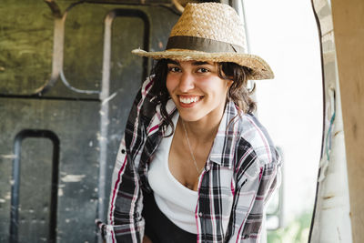 Portrait of smiling young woman wearing hat outdoors