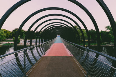 Footbridge over river against sky