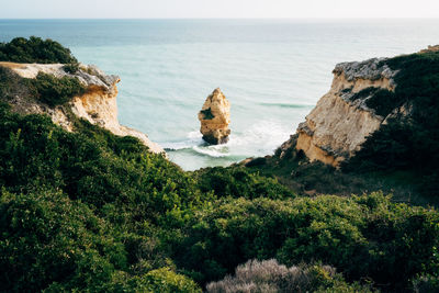 High angle view of cliff by sea against sky