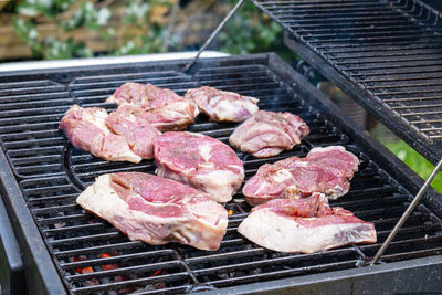 Close-up of pieces of fresh raw meat laid out on a grill grate. barbecue cooking. selective focus