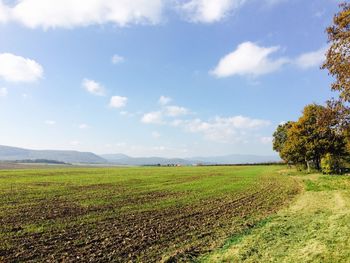 Scenic view of field against cloudy sky