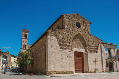 Overview of old church and bell tower in a square at colle di val d'elsa, italy.