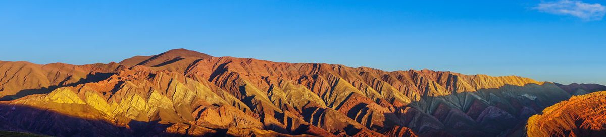 Panoramic view of mountain range against clear blue sky