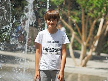 Portrait of smiling girl standing against trees