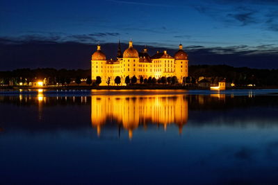 Reflection of illuminated building in lake at night