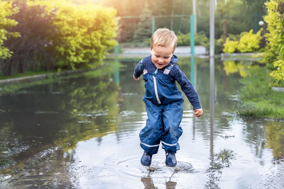 Full length of smiling boy in lake