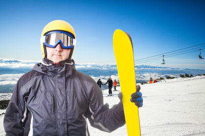 Man standing in snow against sky during winter