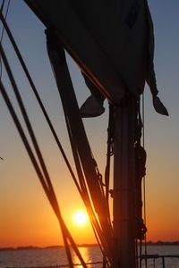 Silhouette of sailboat by sea against sky during sunset