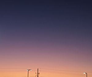 Low angle view of electricity pylon against romantic sky