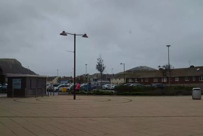 Buildings in town against cloudy sky