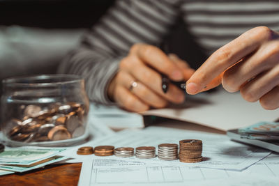 Close-up of hand holding coins on table