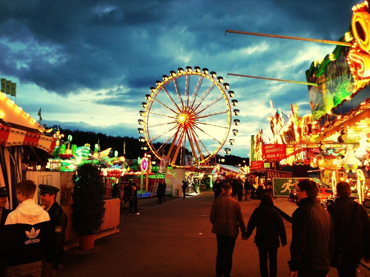 amusement park, amusement park ride, arts culture and entertainment, ferris wheel, sky, large group of people, leisure activity, architecture, built structure, person, men, cloud - sky, building exterior, lifestyles, illuminated, enjoyment, city, cloudy, fun