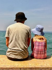 Rear view of man and woman looking at sea