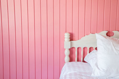 Close-up of man lying on bed against wall