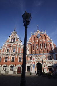 Low angle view of gas light and house of the blackheads at town square against sky