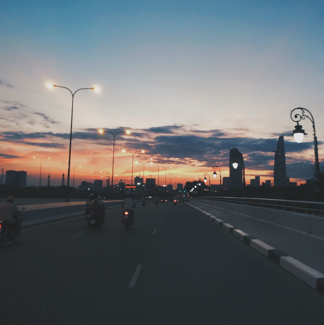 transportation, car, land vehicle, road, mode of transport, road marking, street light, street, sky, the way forward, on the move, traffic, sunset, silhouette, cloud - sky, city street, dusk, city, travel, diminishing perspective