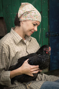 Woman sitting with chicken by door