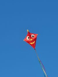 Low angle view of kite against clear blue sky