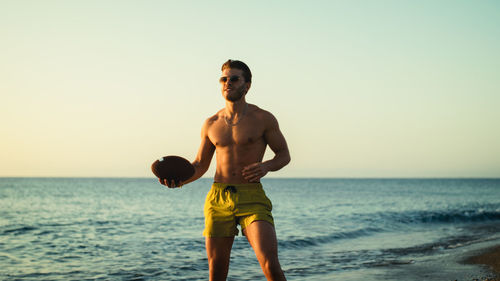 Boy plays football at the sea